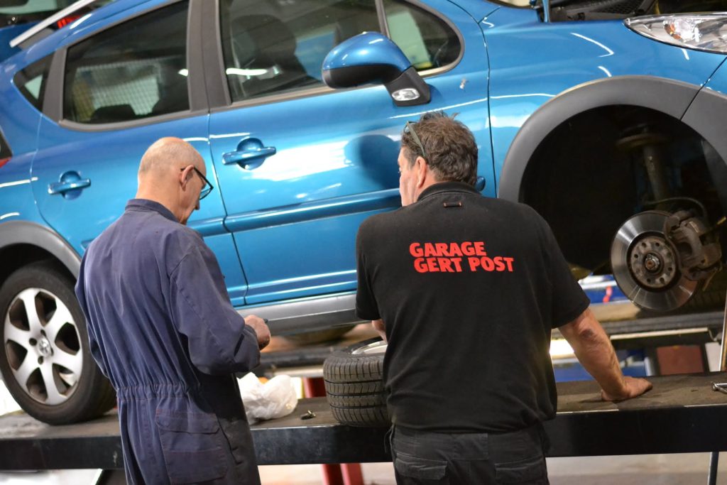 Monteurs bij een auto op de brug bij Garage Gert Post